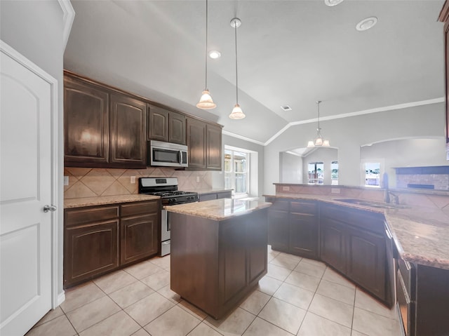 kitchen featuring a center island, appliances with stainless steel finishes, lofted ceiling, tasteful backsplash, and dark brown cabinetry