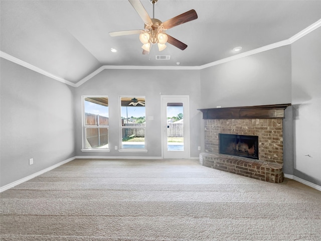 unfurnished living room with crown molding, vaulted ceiling, a brick fireplace, light colored carpet, and ceiling fan