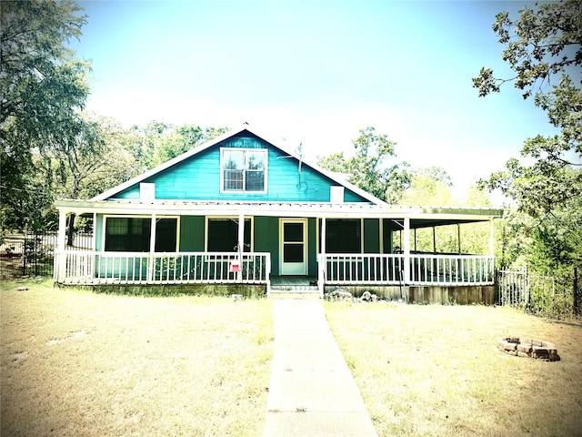 farmhouse featuring a front lawn and a porch