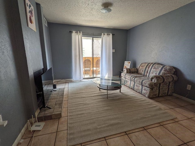 living room featuring a textured wall, a textured ceiling, and tile patterned floors