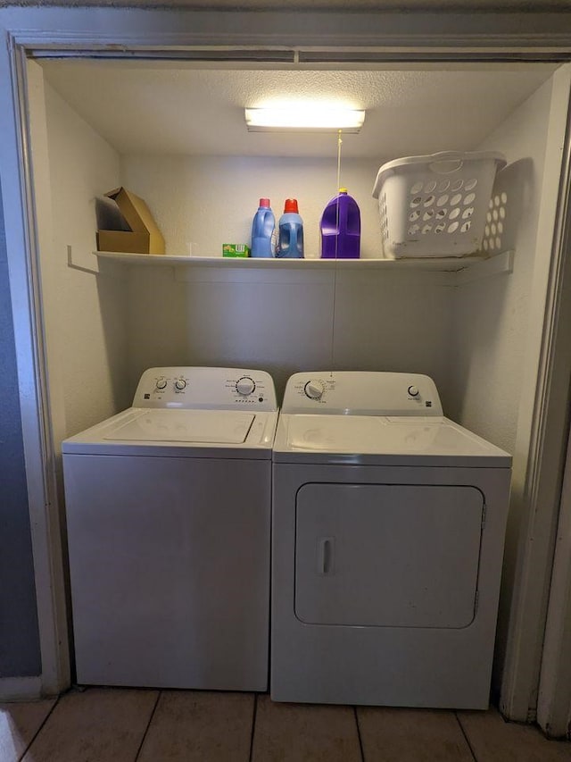 laundry room with laundry area, washing machine and clothes dryer, and tile patterned floors