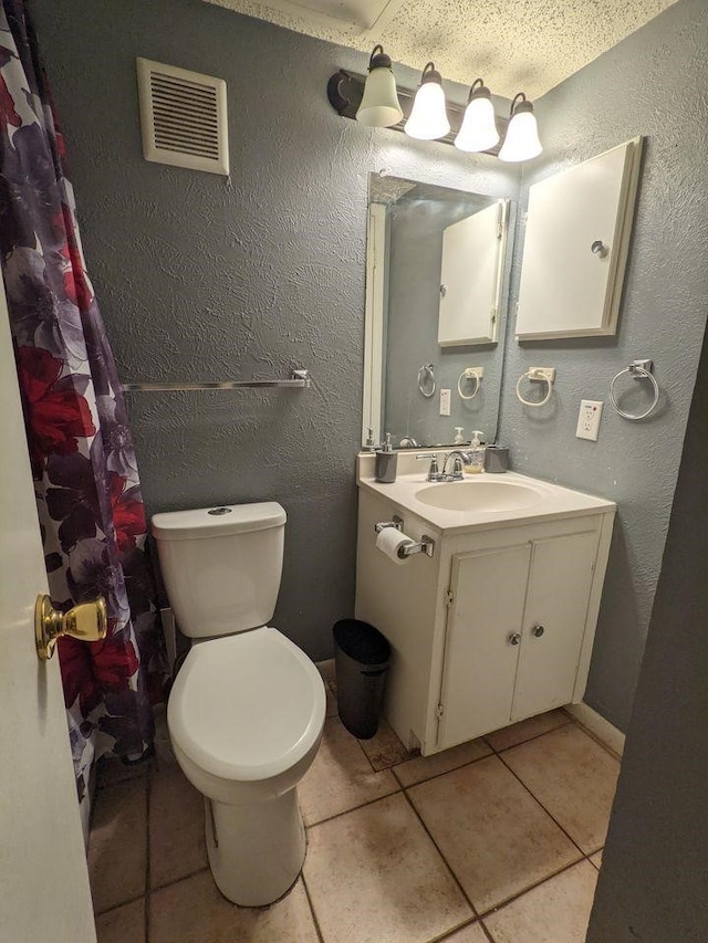 full bathroom with visible vents, a textured wall, toilet, vanity, and tile patterned floors