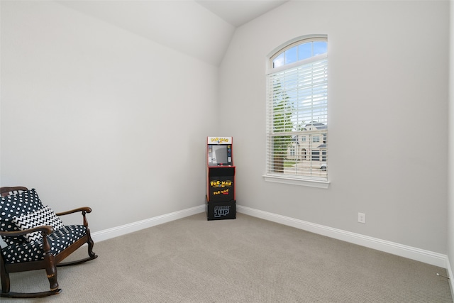 living area featuring plenty of natural light, vaulted ceiling, and carpet