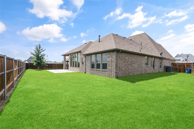 back of house featuring central air condition unit, a yard, and a patio area