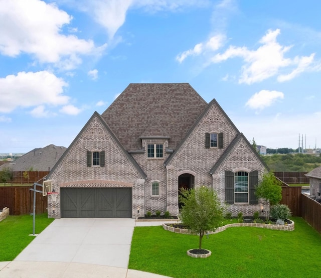 1205 Lake Hills Trl, Roanoke, TX 76262 - french country inspired facade with fence, an attached garage, brick siding, driveway, and a front yard