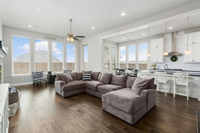 living room with a fireplace, ceiling fan, and dark hardwood / wood-style floors