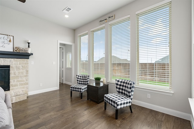 sitting room featuring a fireplace, a wealth of natural light, and dark hardwood / wood-style floors