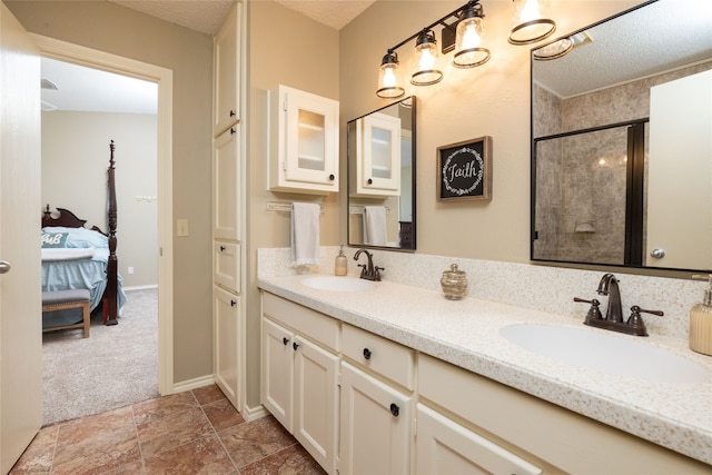 bathroom with vanity, a textured ceiling, and a shower with door