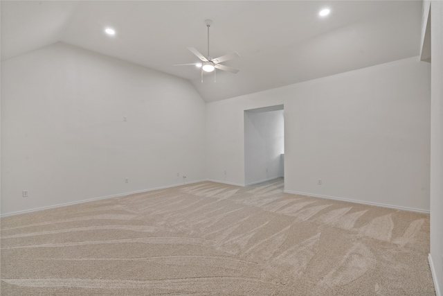 spare room with lofted ceiling, light carpet, and ceiling fan