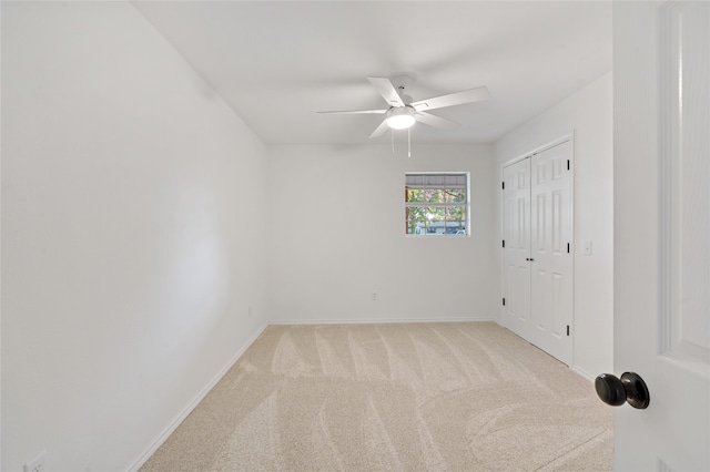 carpeted spare room featuring ceiling fan