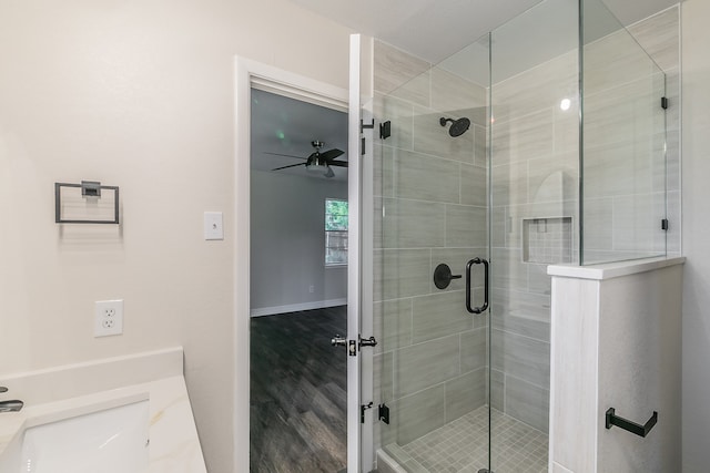 bathroom featuring ceiling fan, hardwood / wood-style floors, walk in shower, and vanity