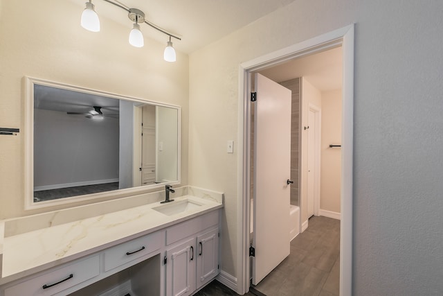 bathroom with shower / washtub combination, track lighting, ceiling fan, and vanity