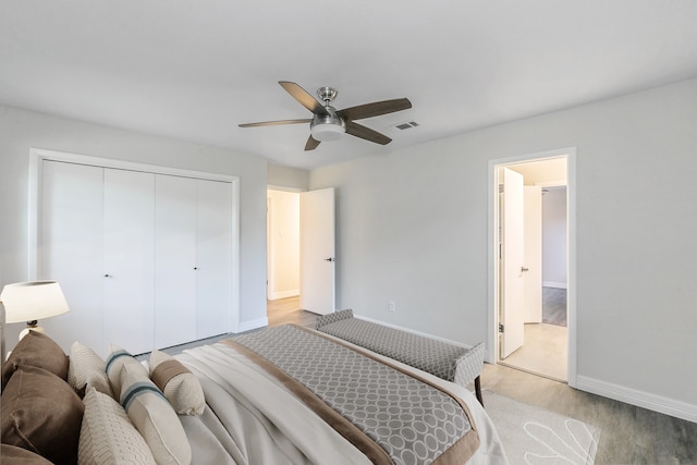 bedroom featuring ceiling fan, a closet, and light hardwood / wood-style flooring