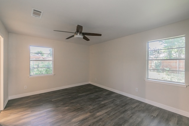 empty room featuring ceiling fan, dark hardwood / wood-style flooring, and a healthy amount of sunlight