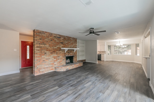 unfurnished living room featuring ceiling fan with notable chandelier, dark wood-type flooring, and a fireplace