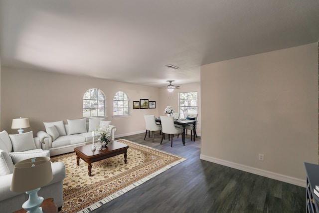 living room with dark wood-type flooring and ceiling fan