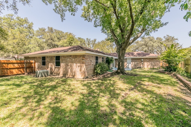 back of property featuring a yard and central air condition unit