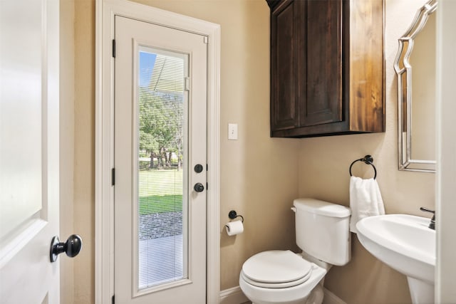 bathroom with toilet, plenty of natural light, and sink