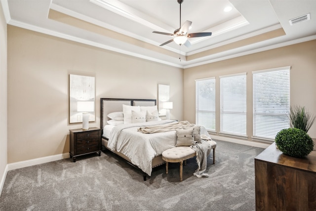 carpeted bedroom with a raised ceiling, ornamental molding, and ceiling fan