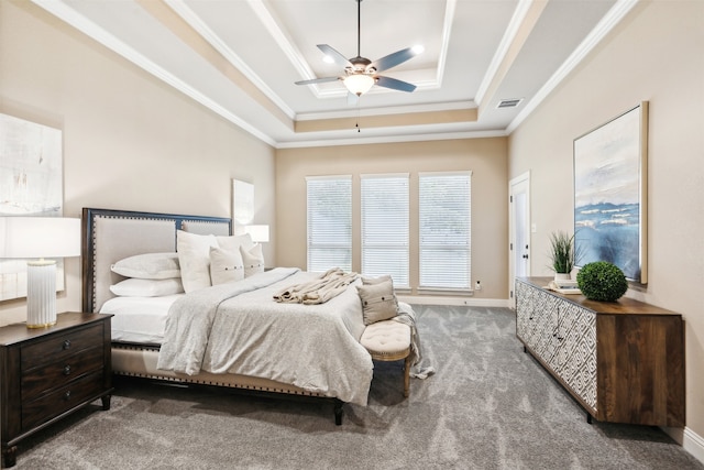 carpeted bedroom with crown molding and a tray ceiling