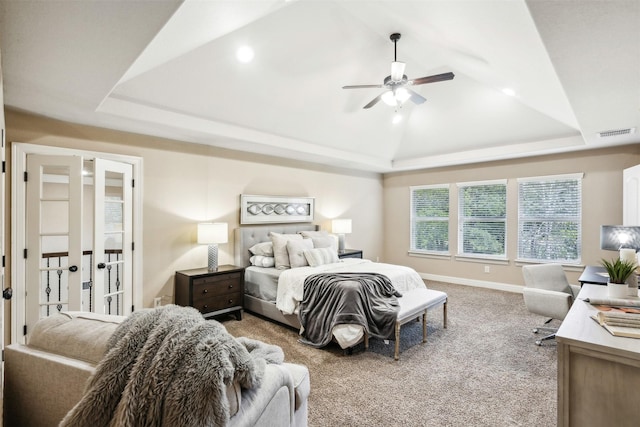 carpeted bedroom with a raised ceiling, ceiling fan, and french doors