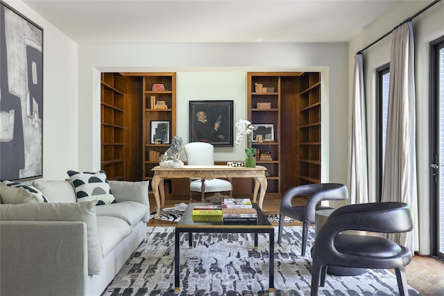 sitting room featuring built in features and hardwood / wood-style floors