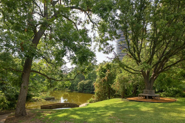 surrounding community featuring a lawn and a deck with water view