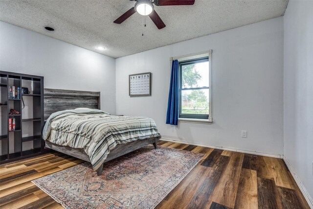 bedroom with ceiling fan, dark hardwood / wood-style floors, and a textured ceiling