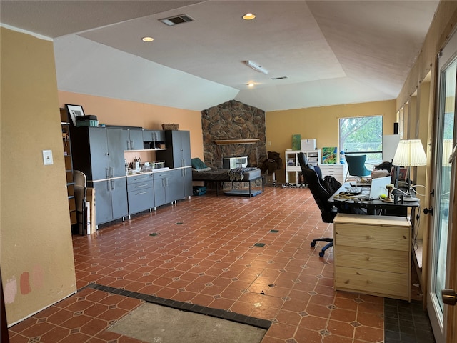 office with vaulted ceiling and a fireplace