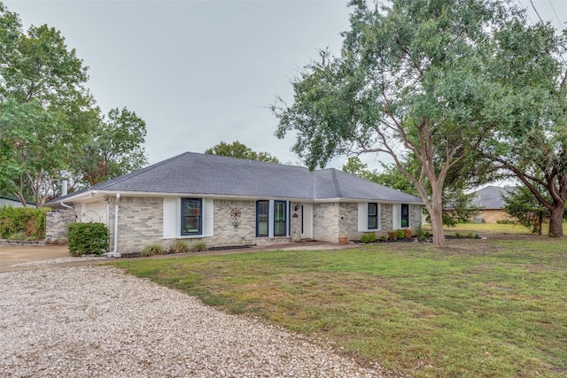 ranch-style house with brick siding, a front lawn, and roof with shingles