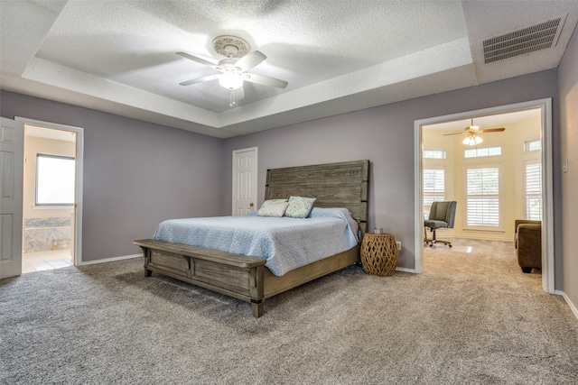 bedroom featuring a raised ceiling, ceiling fan, and carpet floors