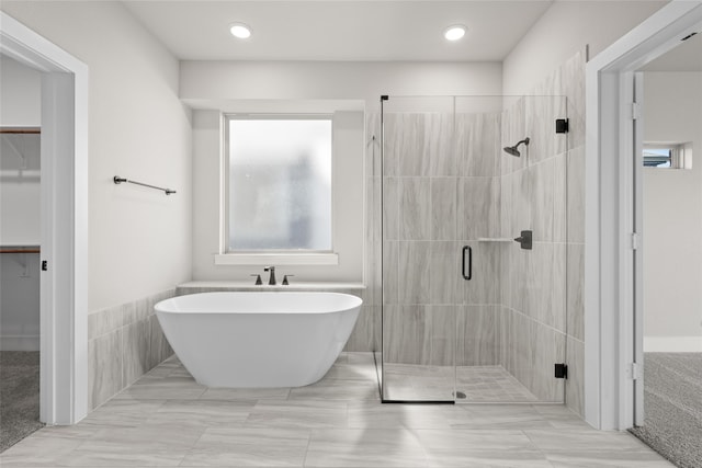 bathroom featuring shower with separate bathtub