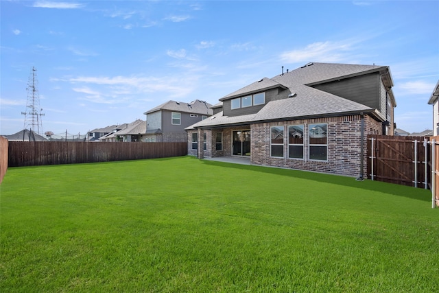 rear view of house featuring a yard and a patio