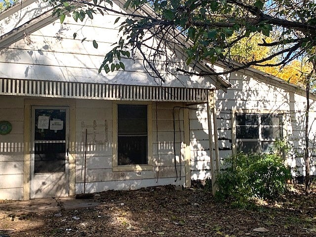 view of side of home featuring covered porch