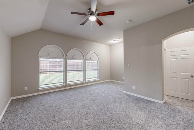 spare room with lofted ceiling, ceiling fan, and light carpet