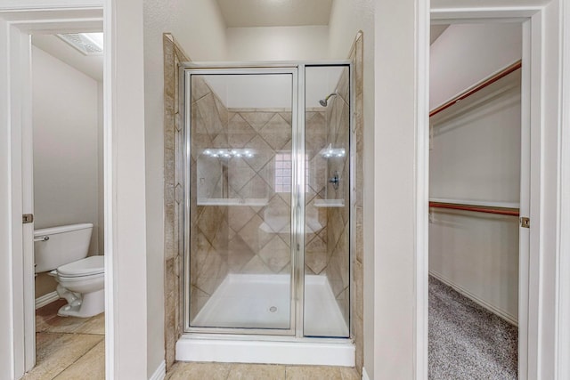 bathroom featuring toilet, an enclosed shower, and tile patterned floors