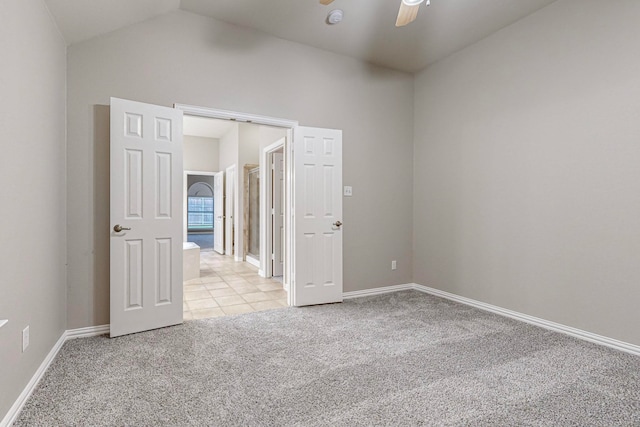 carpeted empty room featuring ceiling fan and vaulted ceiling