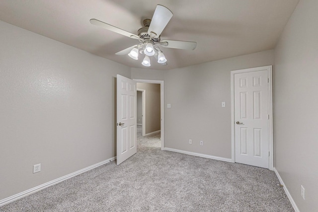 carpeted spare room with ceiling fan