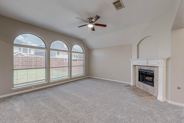 unfurnished living room featuring light carpet, lofted ceiling, ceiling fan, and a tile fireplace