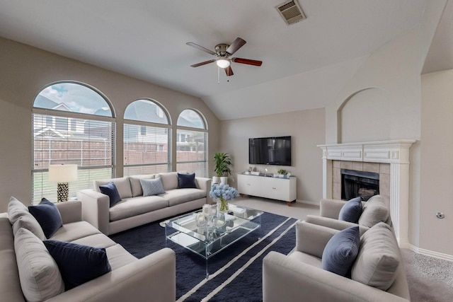 living room with ceiling fan, carpet floors, vaulted ceiling, and a fireplace