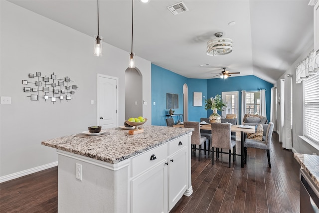 kitchen featuring vaulted ceiling, dark hardwood / wood-style floors, decorative light fixtures, a kitchen island, and white cabinetry