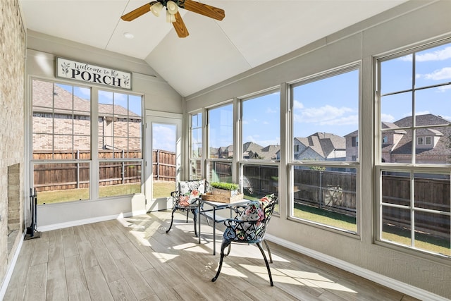 sunroom with plenty of natural light, lofted ceiling, and ceiling fan