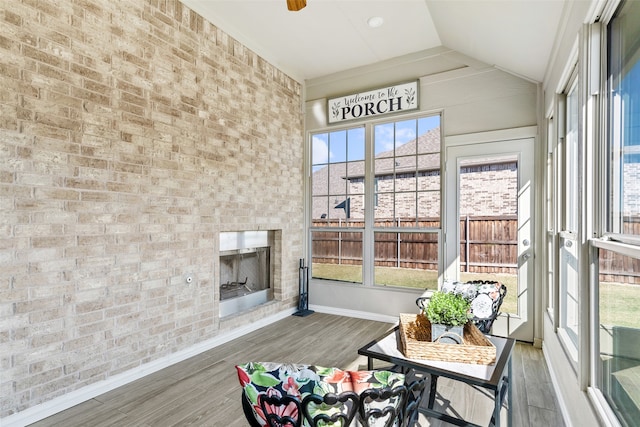 sunroom featuring ceiling fan, a healthy amount of sunlight, and vaulted ceiling