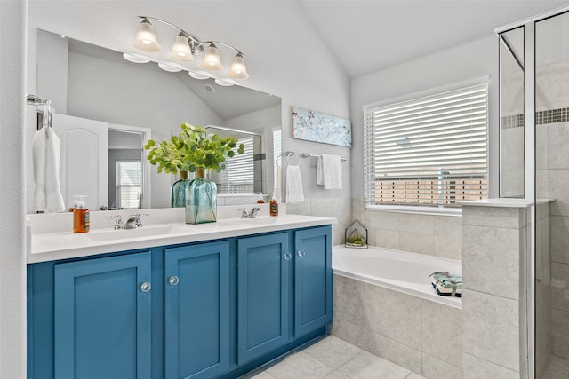 bathroom with tile patterned flooring, vanity, vaulted ceiling, and a wealth of natural light