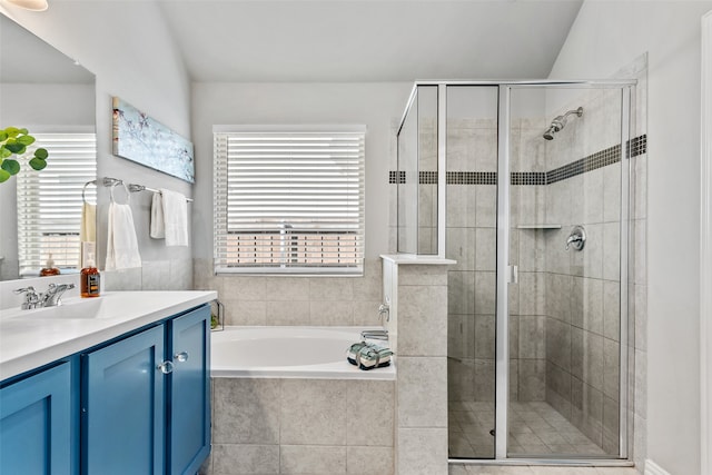 bathroom with vanity, vaulted ceiling, and independent shower and bath