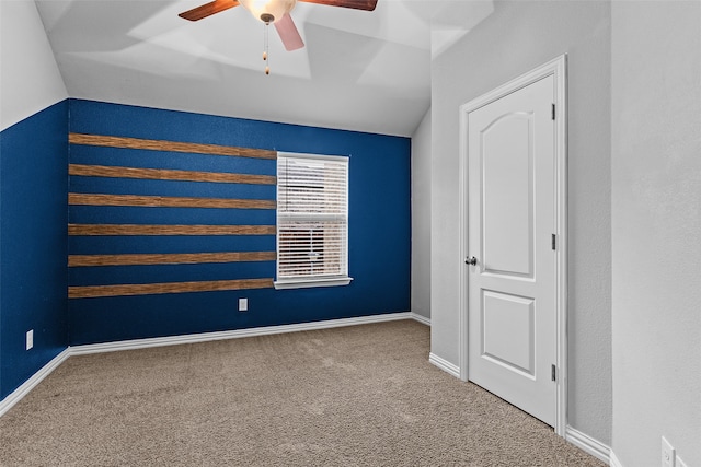 carpeted empty room with ceiling fan and lofted ceiling