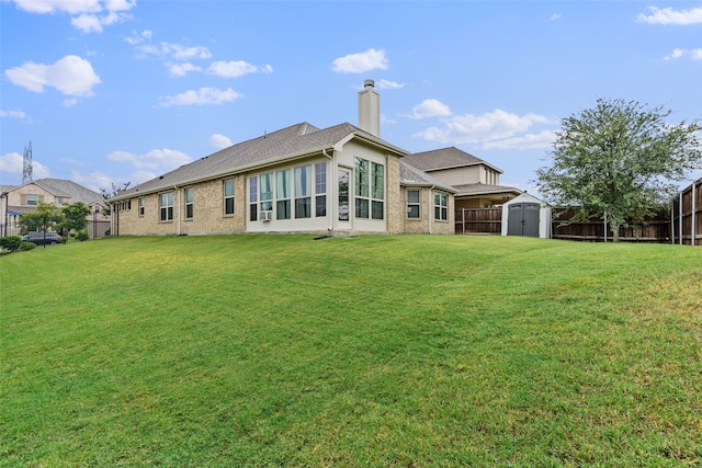 back of property with a storage unit and a lawn