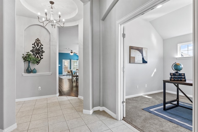 interior space with a notable chandelier, light tile patterned flooring, and vaulted ceiling