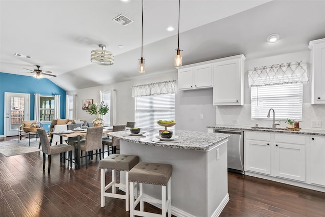 kitchen with dishwasher, dark hardwood / wood-style flooring, white cabinetry, and light stone counters