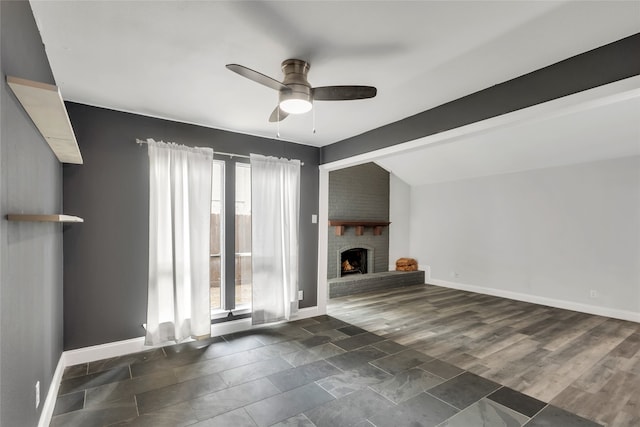 interior space featuring ceiling fan, dark hardwood / wood-style floors, lofted ceiling with beams, and a fireplace